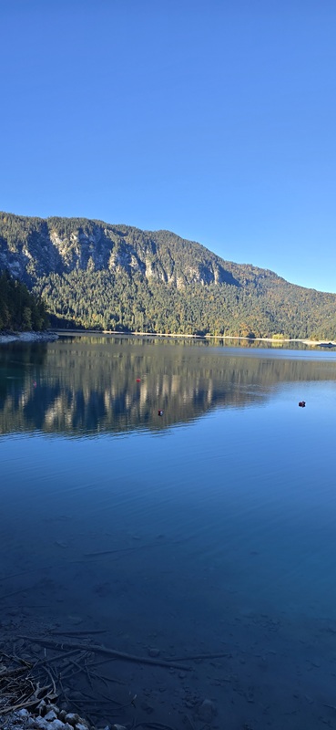 Bergpanorama am Eibsee mit klarer Spiegelung im Wasser bei strahlendem Herbstwetter.