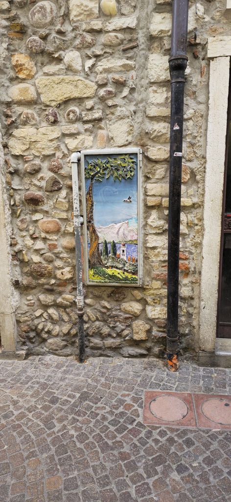 Historische Steinmauer in der Altstadt von Lazise mit dekorativem Spiegel und italienischem Flair.