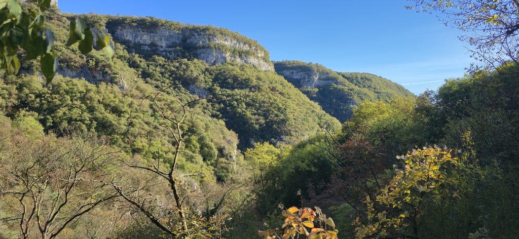 Aussicht auf die grüne Schlucht und die Felslandschaft der Cascate di Molina bei sonnigem Wetter.